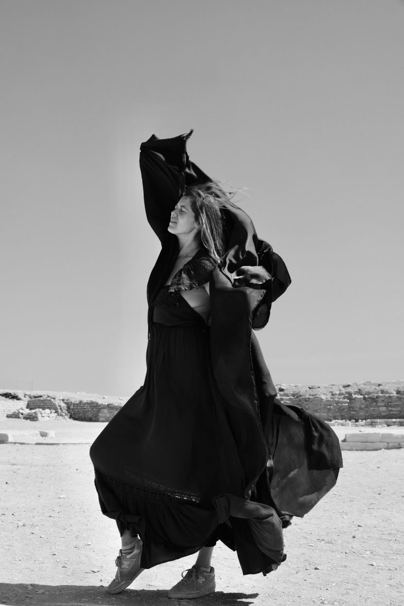 Lady dances in the desert with scarf in a black and white photograph