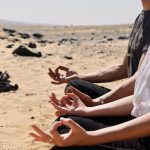 the hands of meditators in mudra poses, sit on the desert of Egypt
